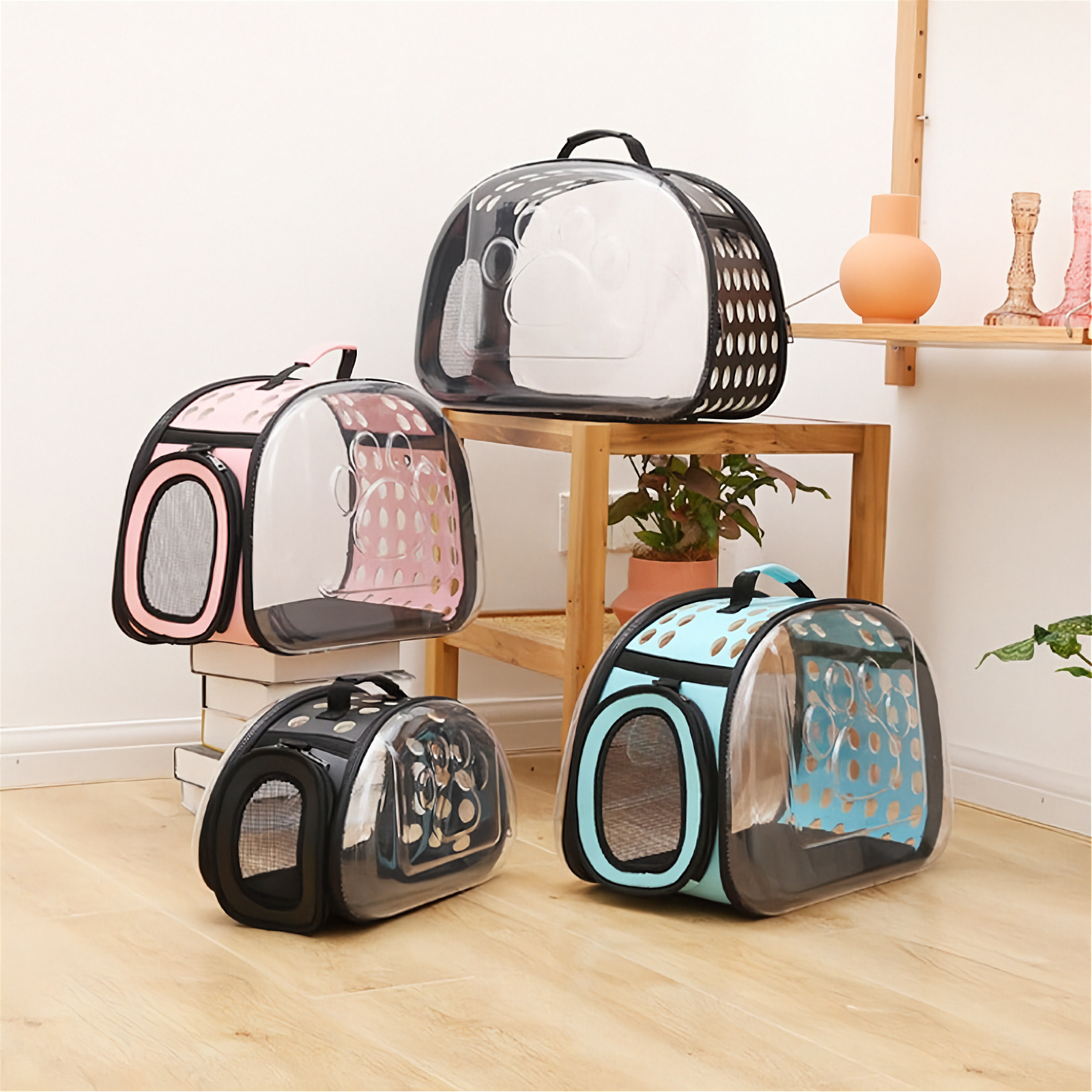 Clear pet carriers with black frames on a wooden floor.